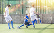© JackF - Youthful football players challenging for ball in midfield zone