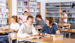 © JackF - School friends spending time together in library; reading books