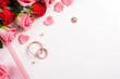 © Carlos Dominique - wedding rings and pink roses on a white background with copy space. AI generated