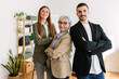 © Xavier Lorenzo - Portrait of successful small group of business people smiling at camera at office. Empowered mature businesswoman standing with young adult coworkers as a team at workplace.