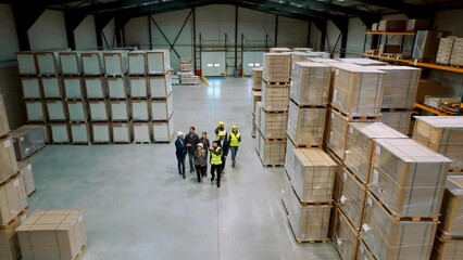 Canvas Print - Top view of full team of warehouse employees walking in warehouse. Team of workers, managers, female director in modern industrial factory, heavy industry, manufactrury.