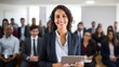 © Krtola  - Mexican young business woman in front of a group