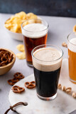 Fototapeta Mapy - Dark stout, lager and ale beer in tall glasses on the table with snacks