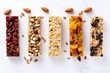 Healthy snack concept featuring energy granola bars with a variety of seeds, nuts, dried fruits, and berries, displayed from a top view on a white marble background.