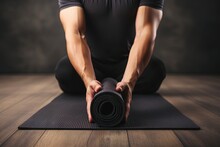 Close Up Of Young Man S Hands Rolling Black Yoga Mat On Wooden Floor Fitness Background With Blank Space Banner Concept