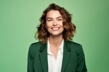 Wall Mural - Portrait of happy smiling businesswoman in green suit, isolated over green background