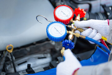 Close-up of Technician man holding monitor tool to check and fix car air conditioner system, Repairman checks car air conditioning system refrigerant recharge, Car air conditioning repair