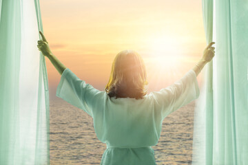 Wall Mural - woman opening curtains Sea view from the bedroom window in the morning and she looks at the sea beach scenery during the morning time travel concept