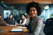 © sam - Successful black businesswoman sitting in a boardroom with her team