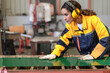 © Nassorn - Latin engineer in safety uniform work in heavy steel engineering factory. Young female hispanic worker wear protective gear checking production machinery equipment in metalwork manufacturing facility