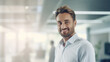© Jasmina - Portrait of a handsome business man standing in the office smiling, co-workers and employees in the background