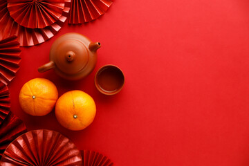 Wall Mural - Chinese new year festival decorations with tangerines, classic clay teapot and red Chinese folded fans.