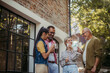 © Westend61 - People at community meeting standing outdoors talking and drinking coffee