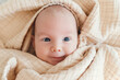 © Westend61 - Smiling cute baby boy wrapped in blanket
