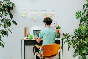 Web designer working on laptop at desk in office