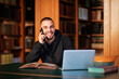 © sepy - Young man using laptop and smartphone in the university library