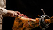 © Pixel_Studio_8 - Mujer cortando delicioso jamón de cebo ibérico con cuchillo sobre fondo negro panorámico con espacio para copiar. Maestra jamonera cortando jamón de cerdo ibérico para degustar
