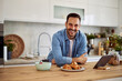 © Jelena - Portrait of a smiling man for a personal home cooking show while leaning on a kitchen counter.