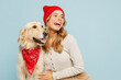 Young cheerful owner woman wear casual clothes red hat bandana hug cuddle embrace her best friend retriever dog look aside isolated on plain pastel blue background studio Take care about pet concept.