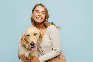 Wall Mural - Young satisfied happy owner woman with her best friend retriever she wear casual clothes cuddle hug dog look camera isolated on plain pastel light blue background studio. Take care about pet concept.