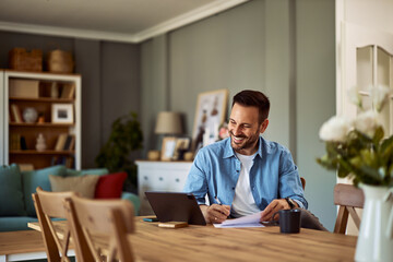 A smiling online tutor having an online class with his students on a tablet and taking notes.