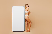 Full Body Young Lady Woman With Slim Body Perfect Skin Wear Nude Top Bra Lingerie Stand Near Big Huge Blank Screen Area Mobile Cell Phone Isolated On Plain Beige Background Lifestyle Diet Fit Concept