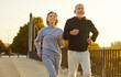 © Studio Romantic - Happy smiling senior people wearing sportswear jogging outdoors having sport workout. Elderly active couple men and women exercising outdoors. Jog workout in nature and healthy lifestyle concept.