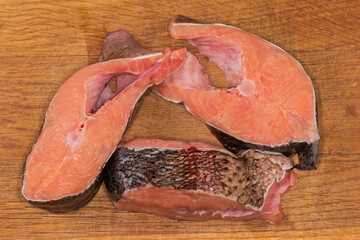 Wall Mural - Raw rainbow trout pieces on wooden cutting board, top view