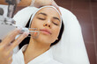 © Dasha Petrenko - Closeup of the face of young woman undergoing laser resurfacing and peeling procedure in spa salon.