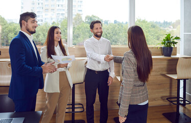 Wall Mural - Successful group of positive and accomplished business people engage in handshake in the office. Agreement shake convey the essence of professional camaraderie, teamwork, and successful partnership.