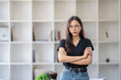 © Wasana - Photo of young freelance businesswoman standing with arms cross, looking at camera.