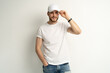 © opolja - Handsome man wearing blank white cap and white t-shirt isolated on white background.