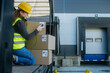 © Halfpoint - Warehouse receiver kneeling inside of truck in cargo area, trailer, barcode scanning delivered items. Receiving clerk holding scanner checking delivered goods against order.