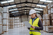 © Halfpoint - Female warehouse worker reading product order, order picking. Warehouse manager checking delivery, stock in warehouse, inspecting products for shipment.
