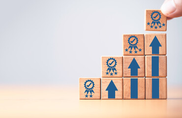 Fototapete - Hand holding the best quality guarantee symbol on the top of wooden stacking with up arrow for continuous quality improvement and customer satisfaction concept.