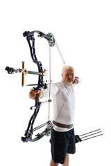 Wall Mural - Man in his 40s, archery athlete with bow and arrow aiming at archery target isolated over white studio background. Concept of professional sport and hobby, competition, action, game