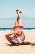 Woman with colorful hat enjoy the beach laying on the sand in summer holiday vacation travel lifestyle - young female caucasian people take a sunbath alone with blue ocean in background