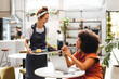 © (JLco) Julia Amaral - Waitress serving a customer coffee on a tray