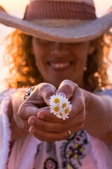 Wall Mural - Happiness and environmental lifestyle cheerful people - woman hold and show a group of daisies flowers in outdoor leisure activity portrait with defocused background
