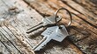 A shiny metal key with a silver-colored house-shaped keychain attached, symbolizing homeownership, real estate investment, and the concept of buying a new home.