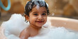 © SnowElf - Indian Baby smile and bath in a bubble bath with soapy bubbles. Joyful bathing kid, daily routine, washing baby.