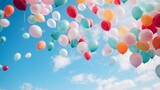 青空に飛んでいく大量のカラフルな風船
