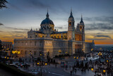 Fototapeta Most - Madrid, Spain 28-12-2022 The Almudena Cathedral during a colorful sunset, it is the most important  and Catholic religious building in Madrid and a visit is free of charge except for the crypt  