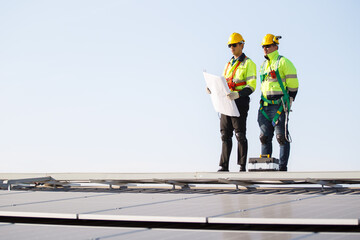  Professional electric engineers survey and inspect solar panels installation on the factory metal sheet roof top.