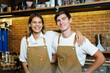 Portrait of male and female coffee shop employees standing behind the counter bar, diverse ethnicity coffee shop employees express their beautiful smile and look at camera. Occupation concept.