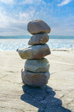 Fototapeta Tulipany - Stacked Rocks balancing, stacking with precision. Stone tower on the shore. Copy space