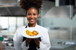 Portrait Happy African American female show omelet while working as chef in a restaurant. Cooking class. culinary classroom. happy young african woman students cooking in cooking school.