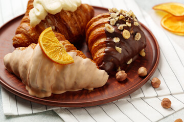 Wall Mural - Glazed croissants on clay plate on table