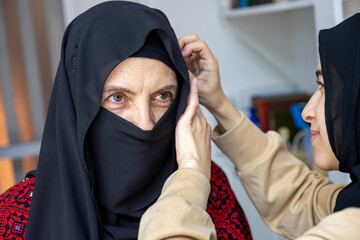 young female adjusting veil for her mother