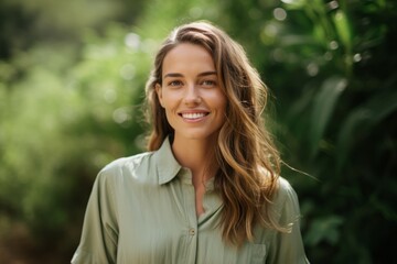 Wall Mural - Portrait of a beautiful young woman in a green shirt smiling at the camera